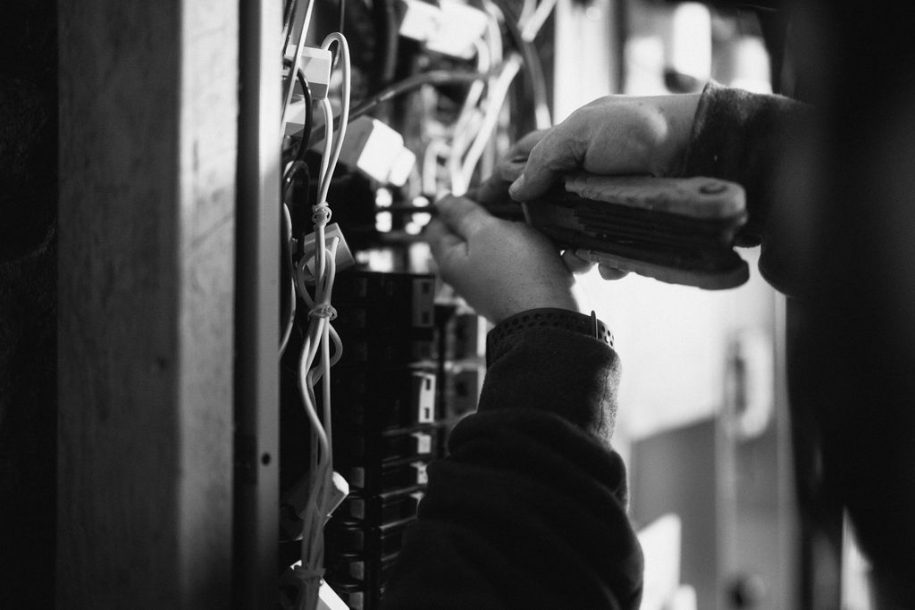 Close-up of a Blackout Electric technician working at an electrical panel