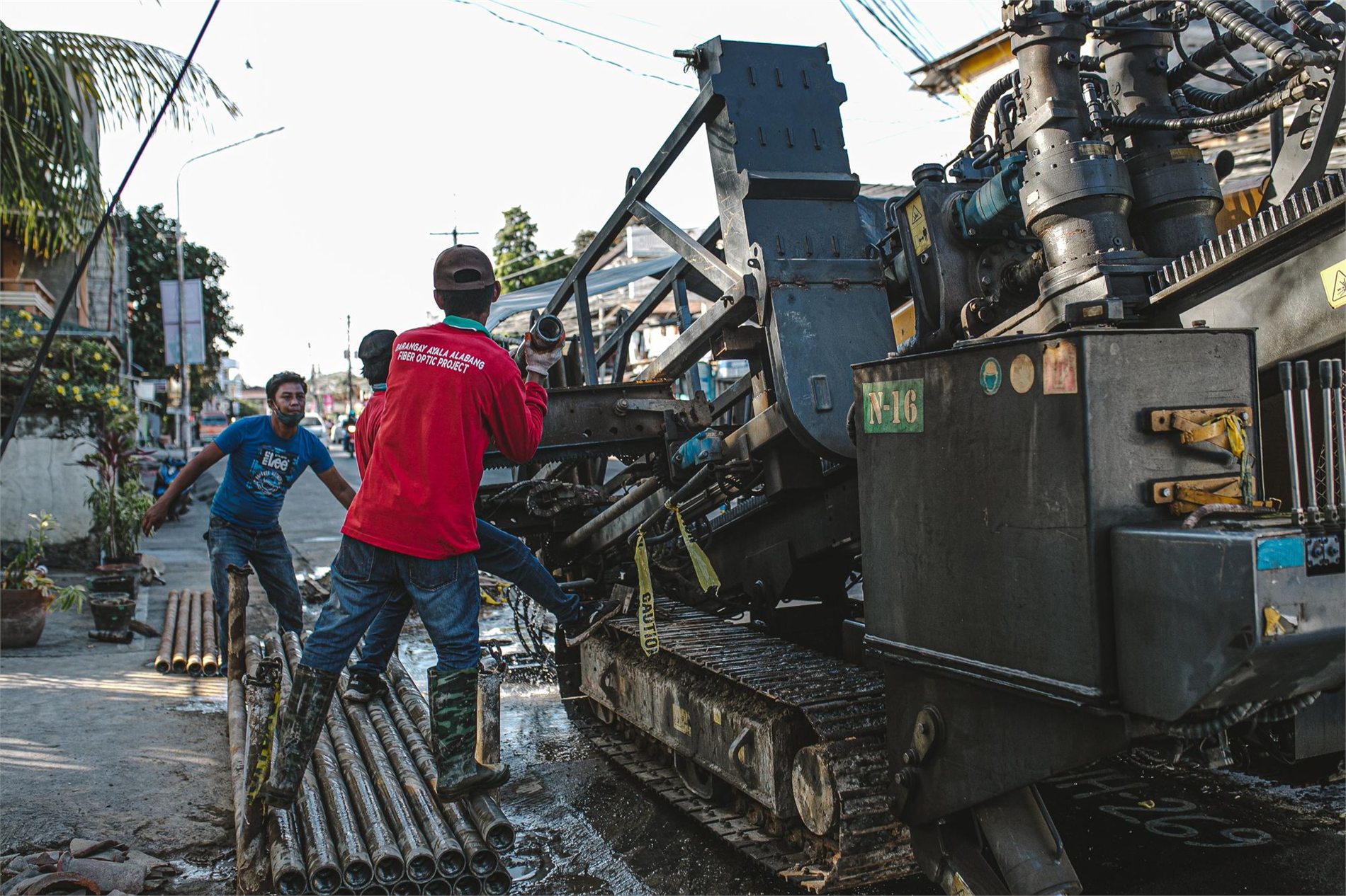 Construction crew operating directional boring equipment beneath a street