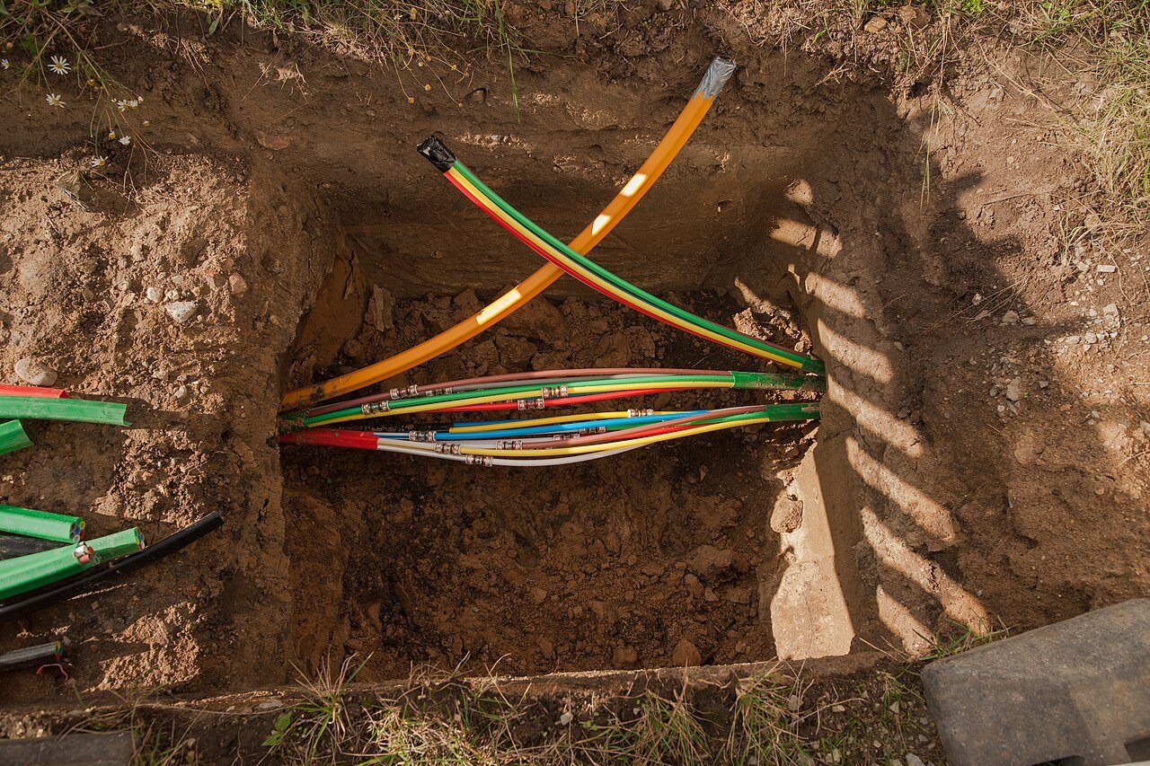 Underground conduit emerging in an access pit after horizontal directional drilling