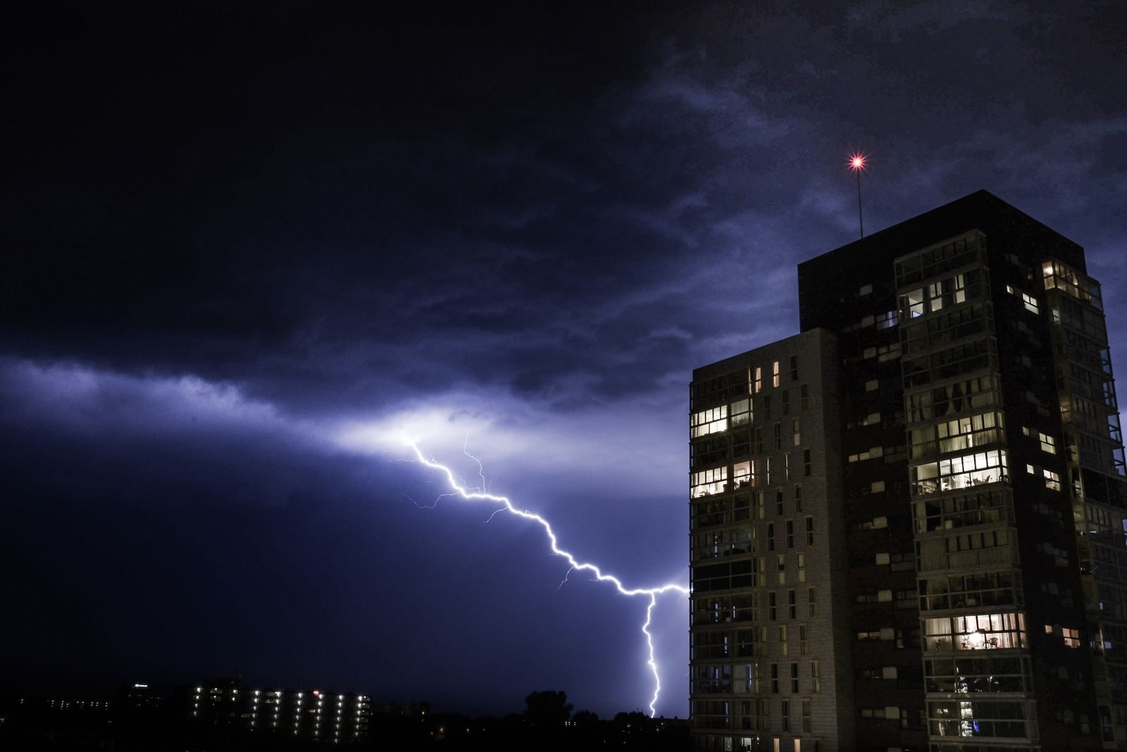 Lightning illuminating a commercial building during a thunderstorm