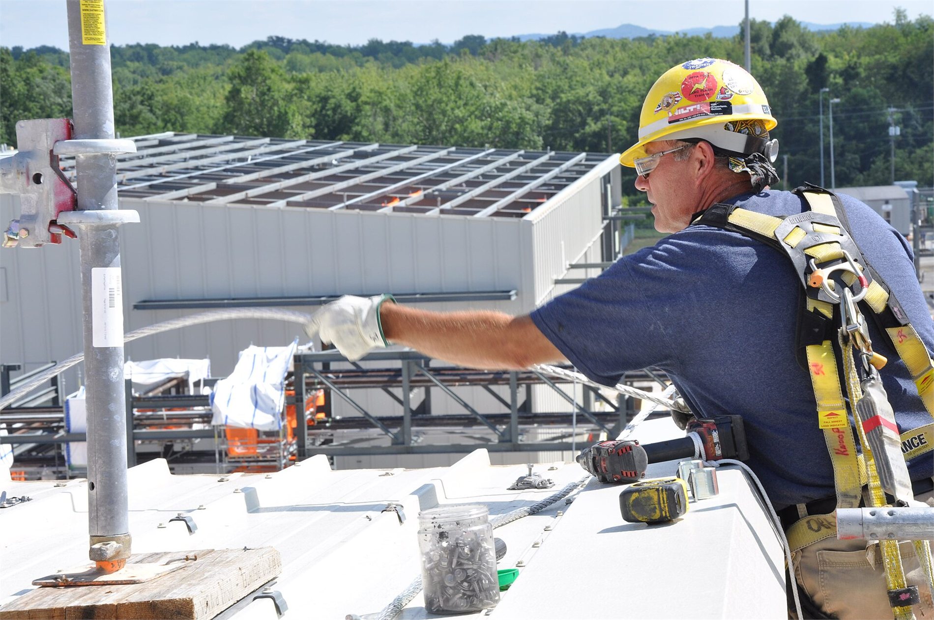Electrician installing lightning protection conductors on a commercial facility roof