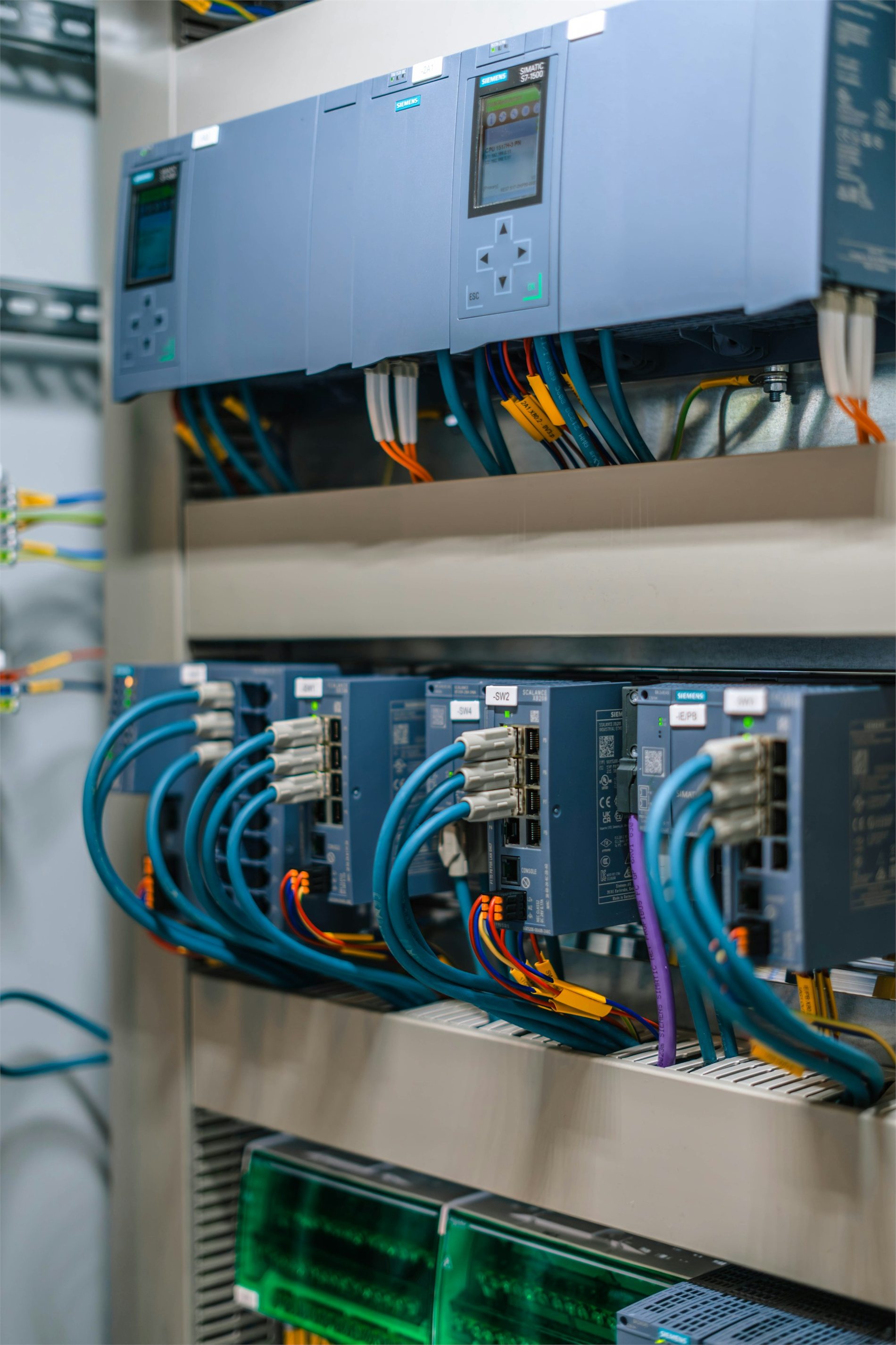 Installed industrial PLC control panel with networked automation modules and labeled wiring