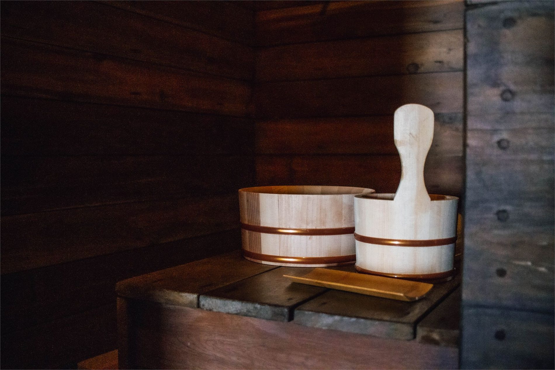 Wooden sauna interior with a traditional bucket and ladle